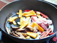 放入少許油熱鍋後，將辣椒、香菇、胡蘿蔔、蒜末、五花下鍋拌炒煸香