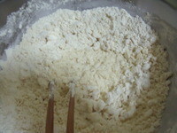 中筋麵粉跟塩放在盆中,沖入滾中攪拌後再倒入冷水拌勻。